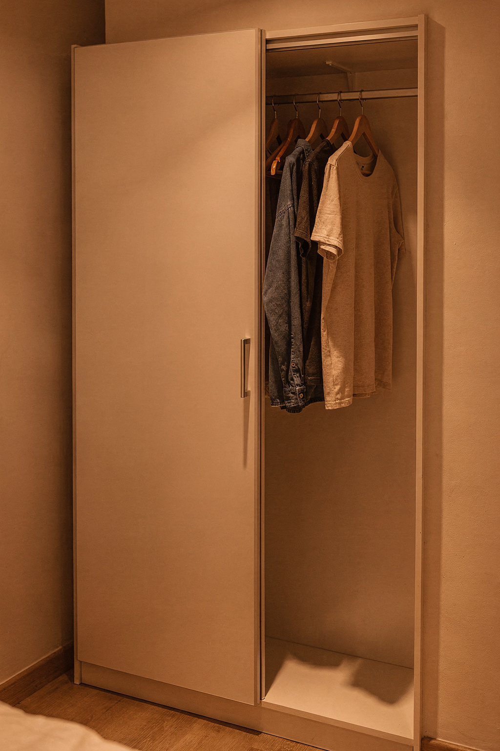 Schmaler Kleiderschrank mit Schiebetüren im kleinen Schlafzimmer spart Platz.
