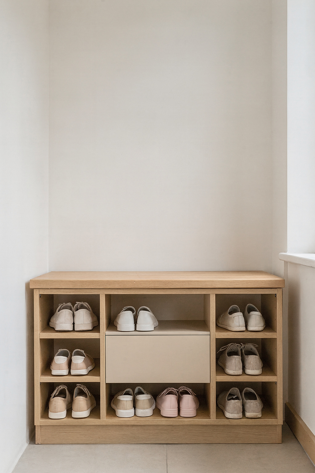 Schmale Nische mit eingebautem Schuhschrank und Sitzbank bietet Stauraum im Eingangsbereich.
