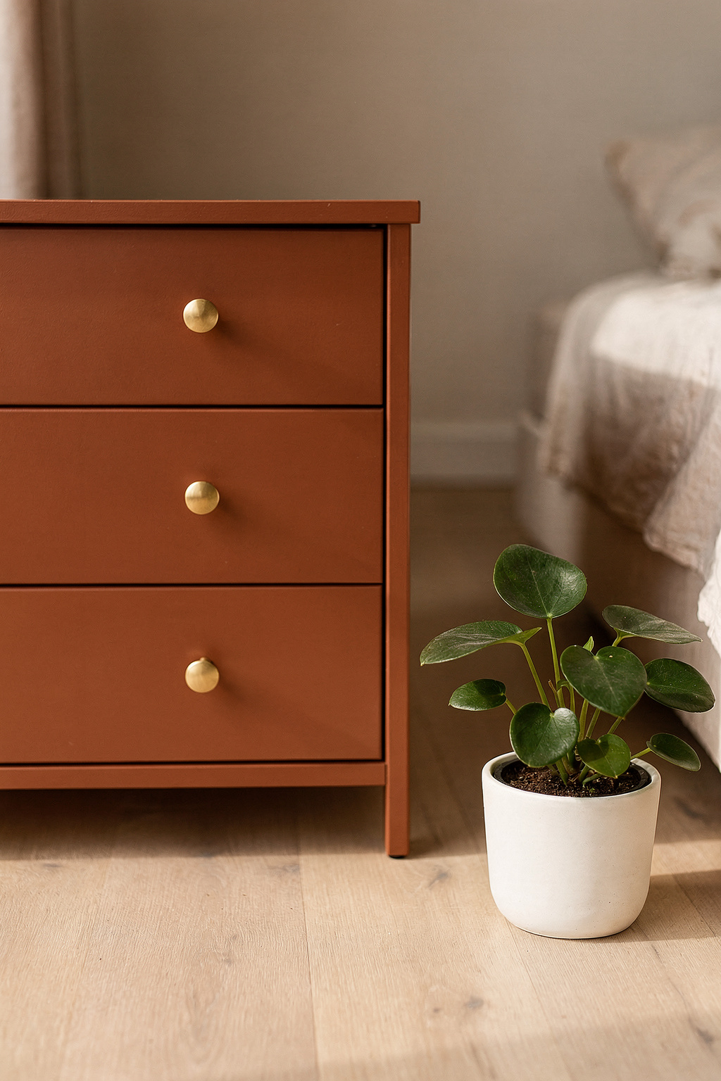 Eine mit Terrakottafarbe gestrichene IKEA RAST Kommode mit goldenen Griffen steht auf hellem Holzboden.