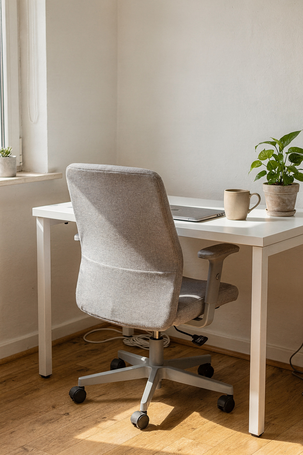 Ergonomischer Bürostuhl am Schreibtisch in einem hellen Arbeitszimmer mit natürlichem Licht.