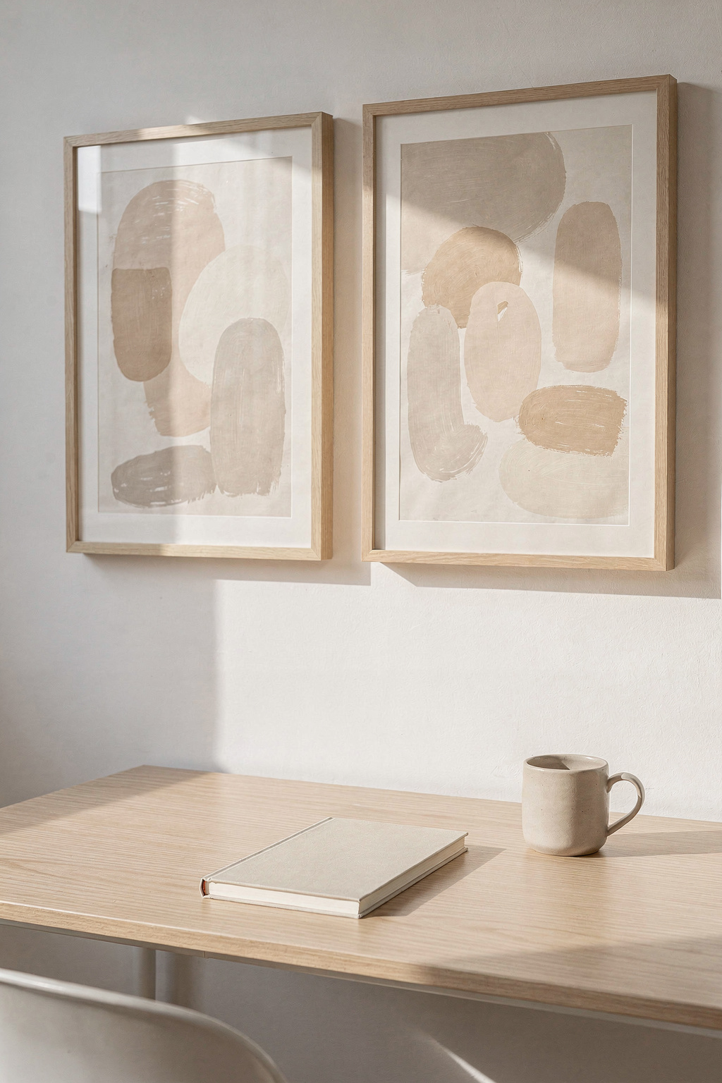 Motivierende Wandbilder in schlichten Rahmen über einem aufgeräumten Homeoffice Schreibtisch mit natürlichem Licht.