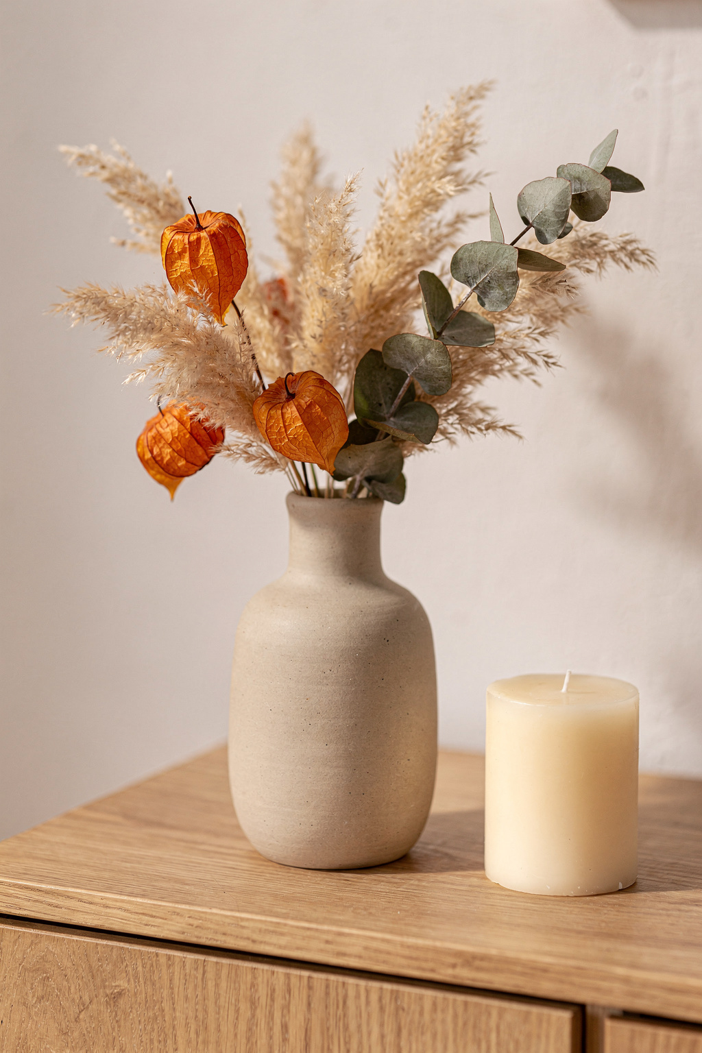 Herbstliche Trockenblumen in einer schlichten Vase als günstige Wohnzimmerdeko im Herbst.