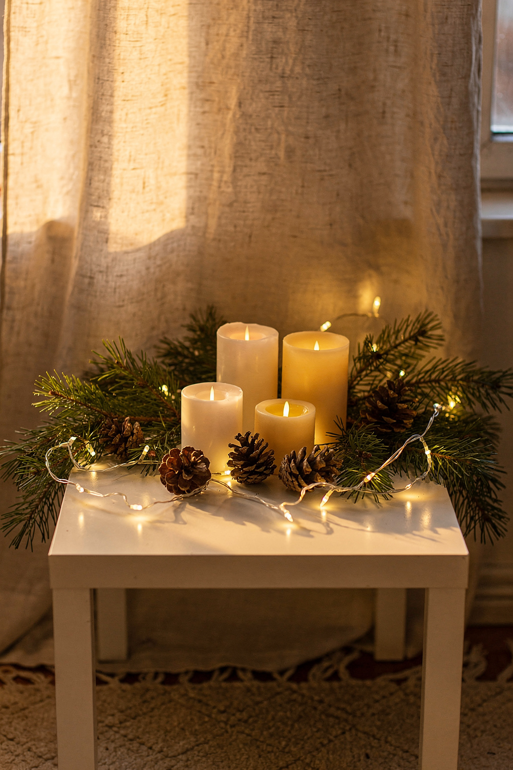 Eine IKEA LACK Beistelltisch als Weihnachtsdeko mit Lichterkette, Tannenzweigen und kleinen unlabeled Kerzen.
