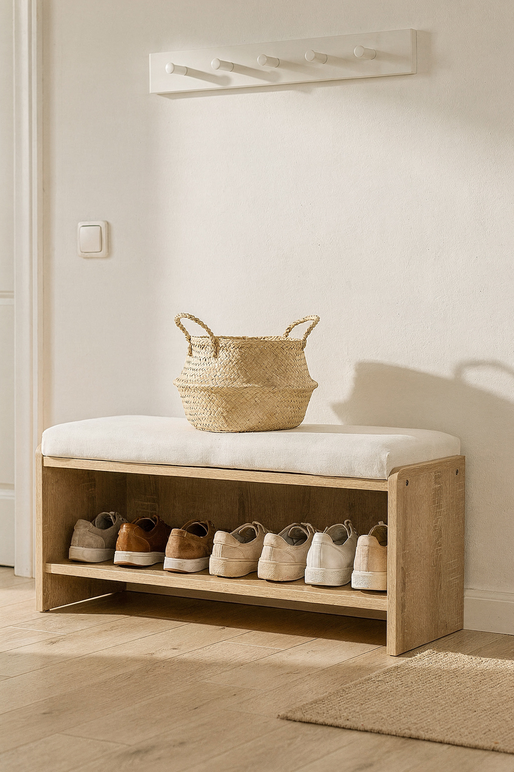 Eine Sitzbank mit Schuhschrank im Flur aus hellem Holz mit ordentlich sortierten Schuhen darunter.