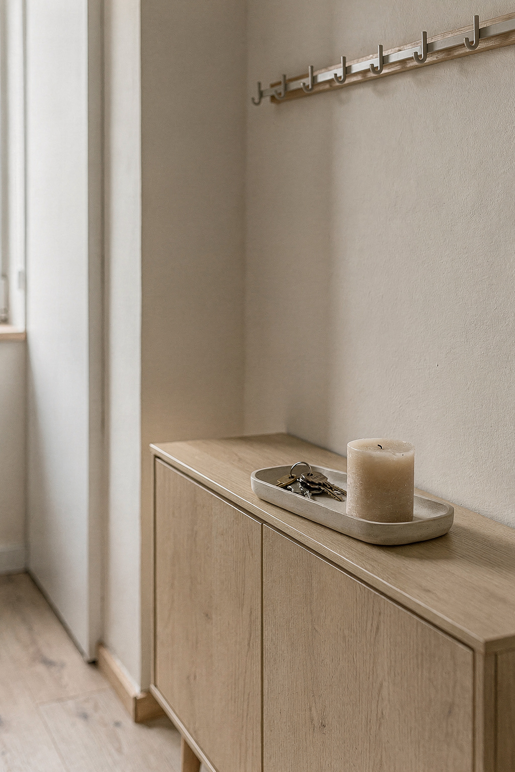 Schmales Sideboard im Flur mit Schlüsselhaken und Ablagefach für Alltagsgegenstände.