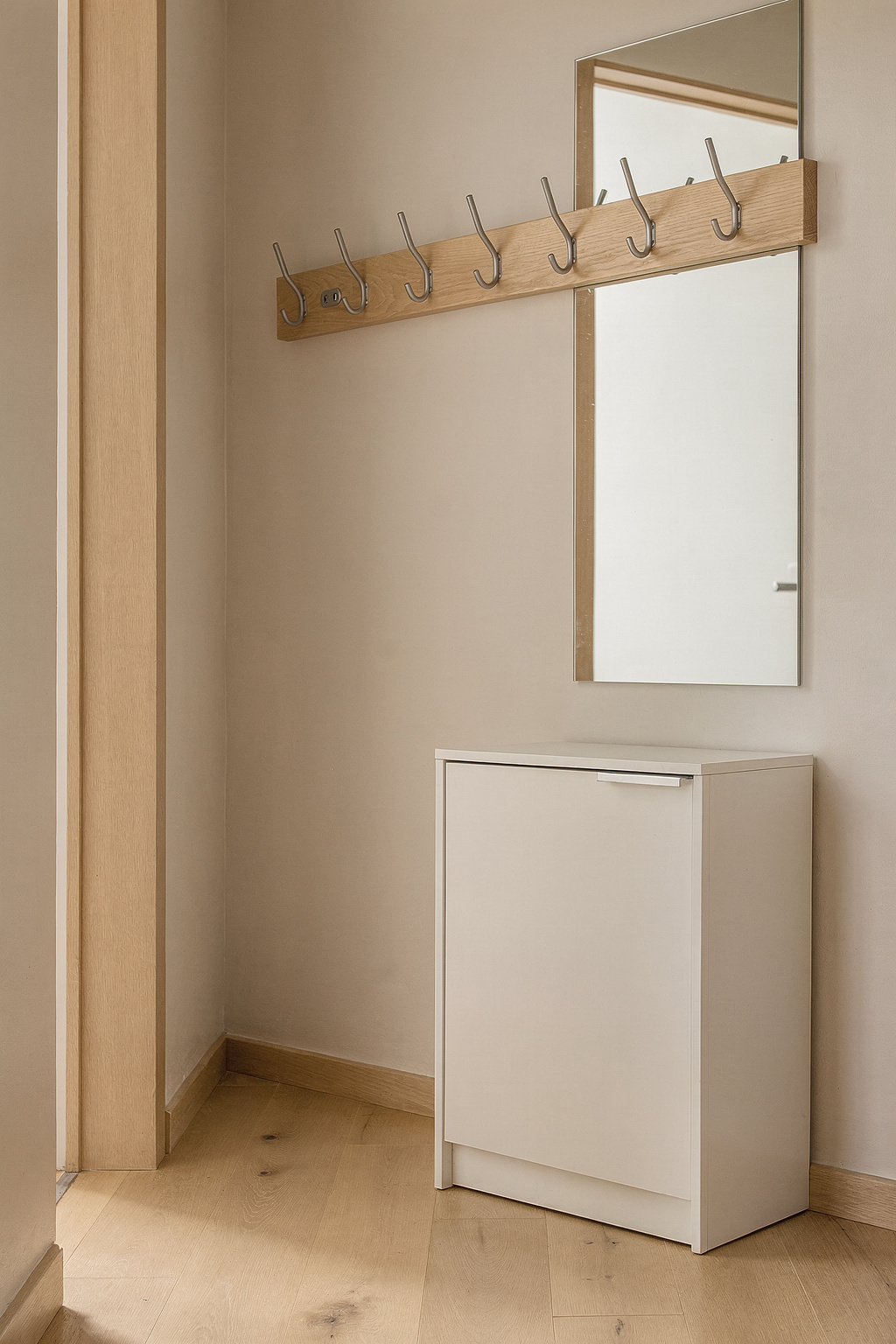 Schmaler Flur mit platzsparendem Garderoben-Set aus Schuhschrank, Hakenleiste und Wandspiegel in hellem Design.